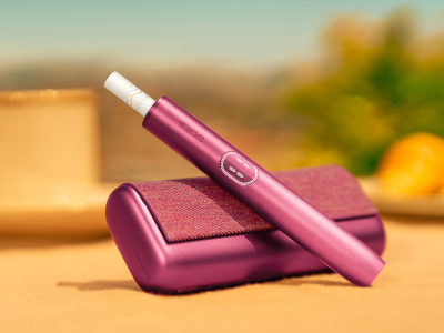 شخص يحمل علبة IQOS غير مفتوحة بعد.